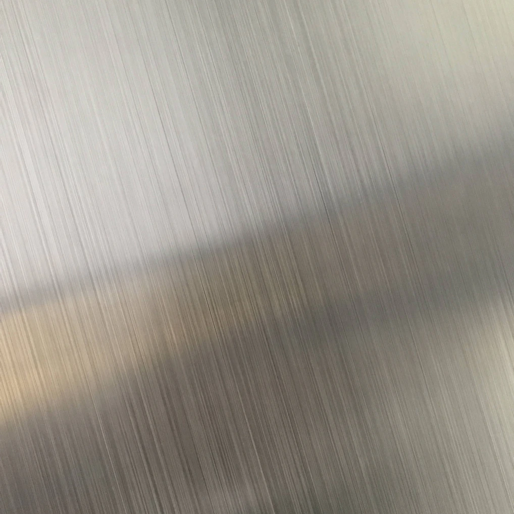 A brushed metal surface with fine vertical lines and a diagonal light reflection