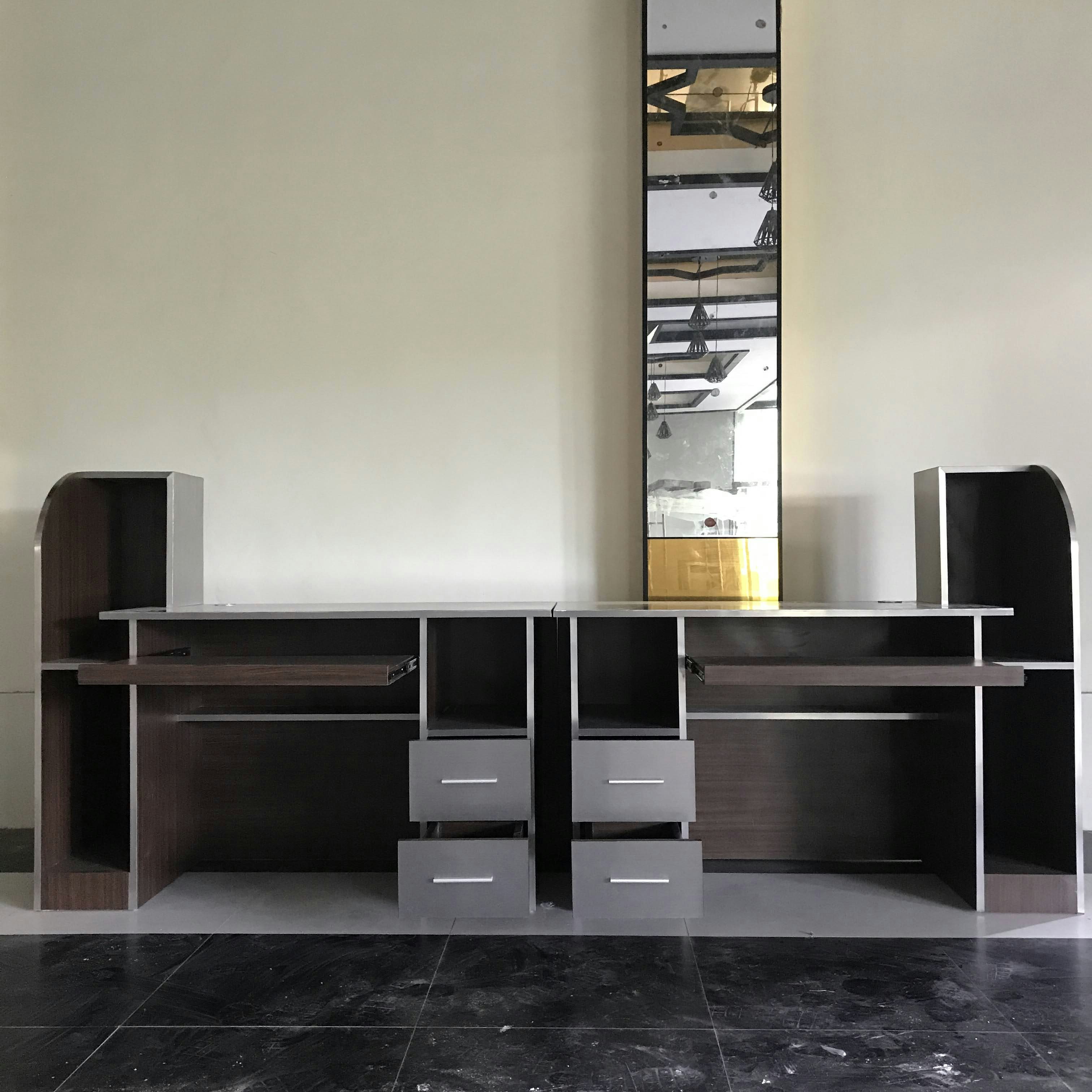 a room with a computer and a shelf with drawers