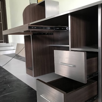 A skilled installer fitting sleek laminate cabinets in a modern hotel guest room.