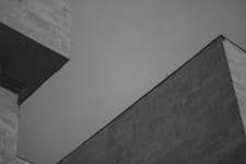 a grey building with a black roof