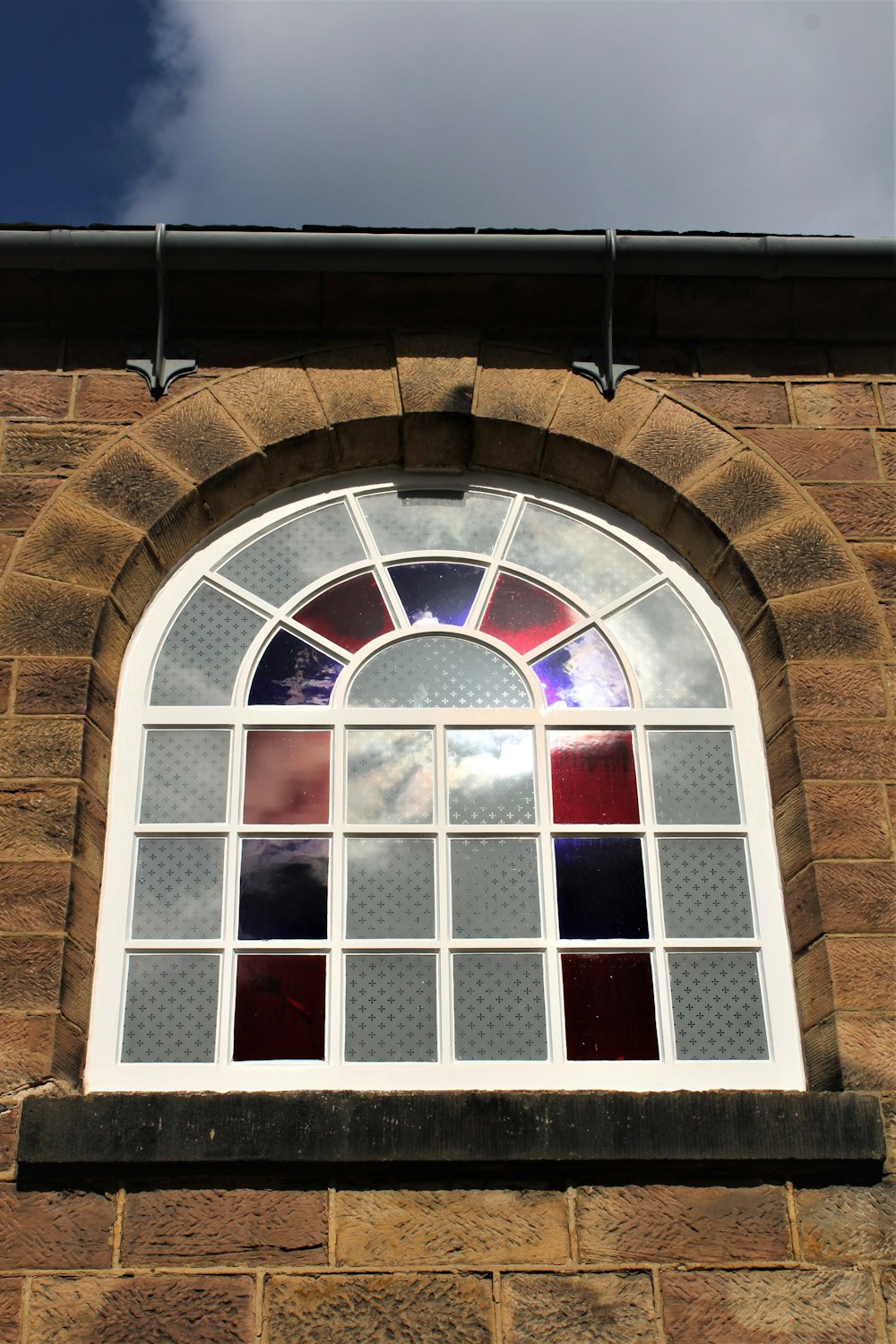 a window with a brick building in the background