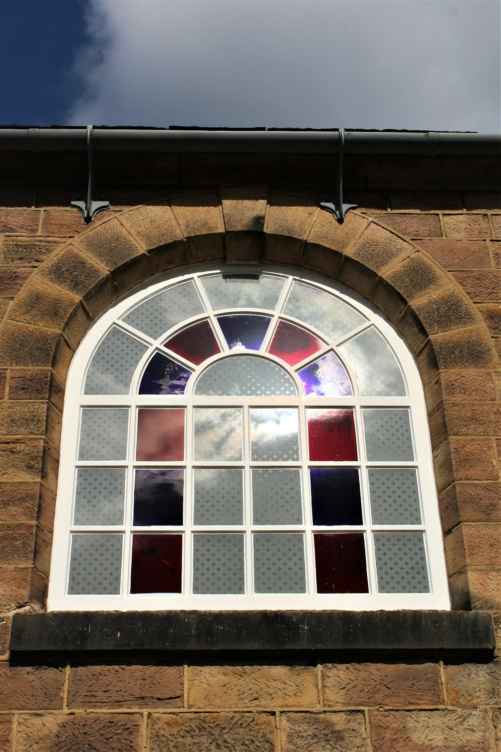 Ein Fenster mit einem Backsteingebäude im Hintergrund