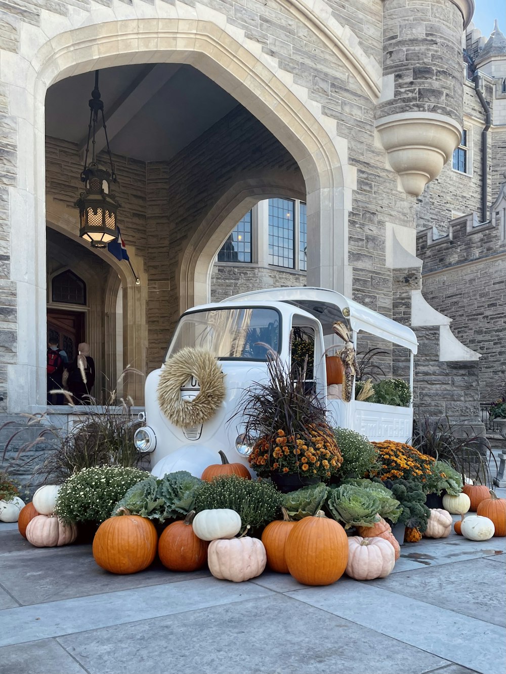 a car parked in front of a building with pumpkins in front