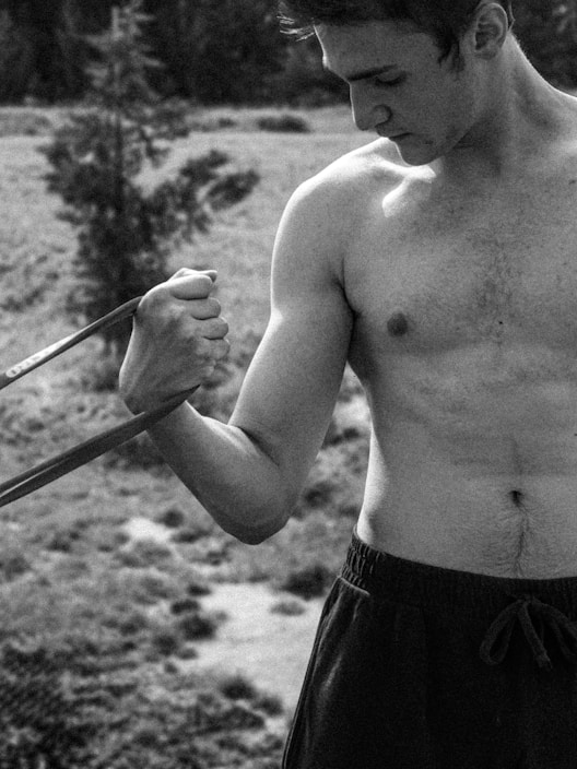 Athlete stretching with a resistance band outdoors in natural light.