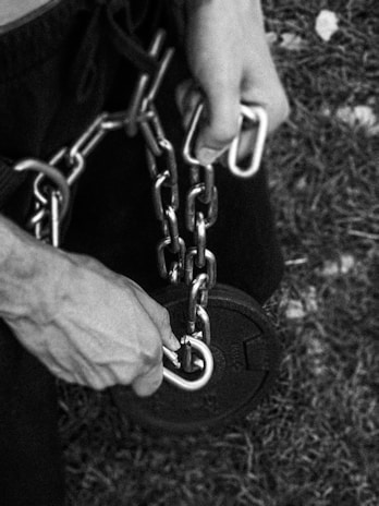Close-up of hands gripping heavy weights, symbolizing discipline and effort.