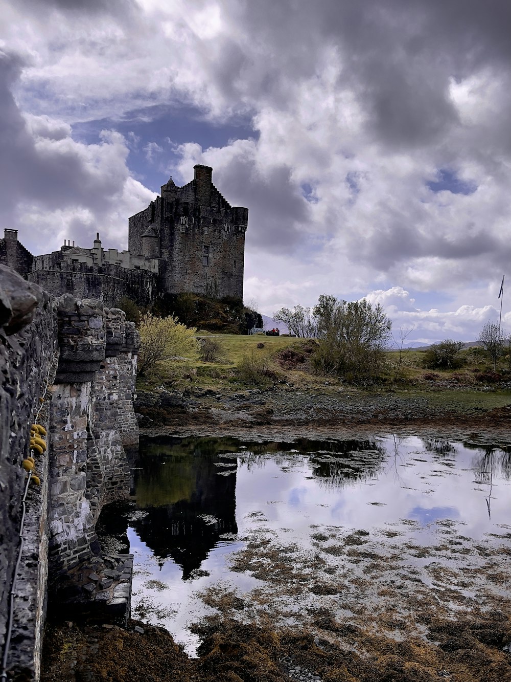 a castle on a hill with Eilean Donan in the background