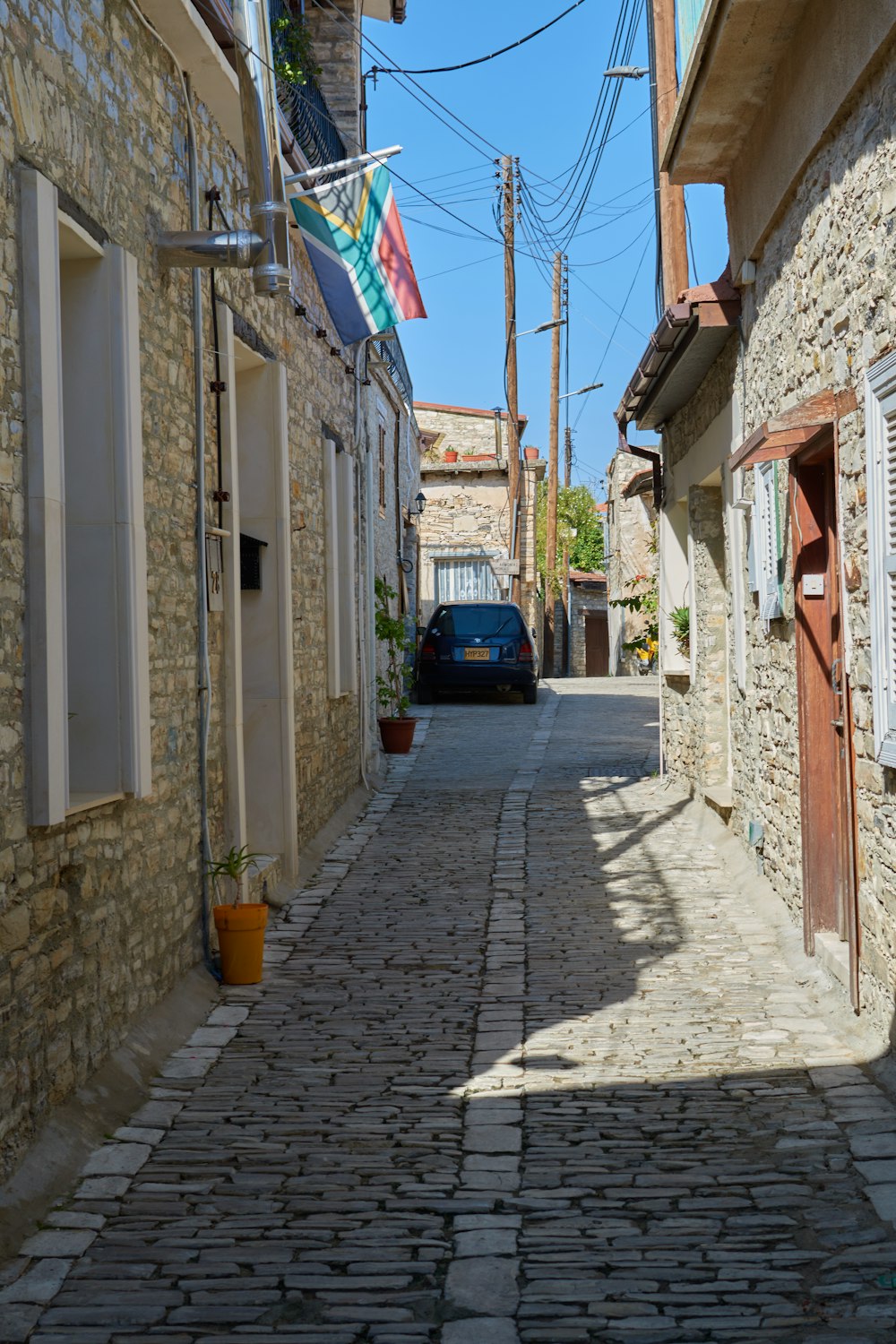 a car parked on a cobblestone street between buildings