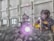 A person wearing protective gear is welding a large metal pipe indoors. Sparks and bright light emanate from the welding process, with the individual holding the welding apparatus with one hand while steadying it with the other. The workspace has industrial features, with walls, windows, and various machinery visible.