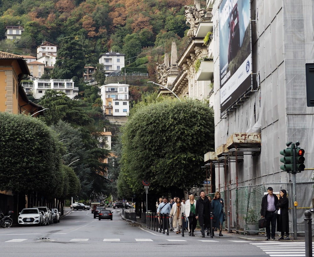 a group of people standing on the side of a street