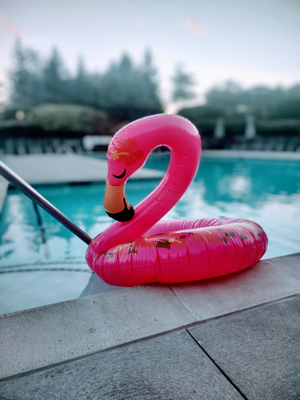 a pink plastic toy by a pool