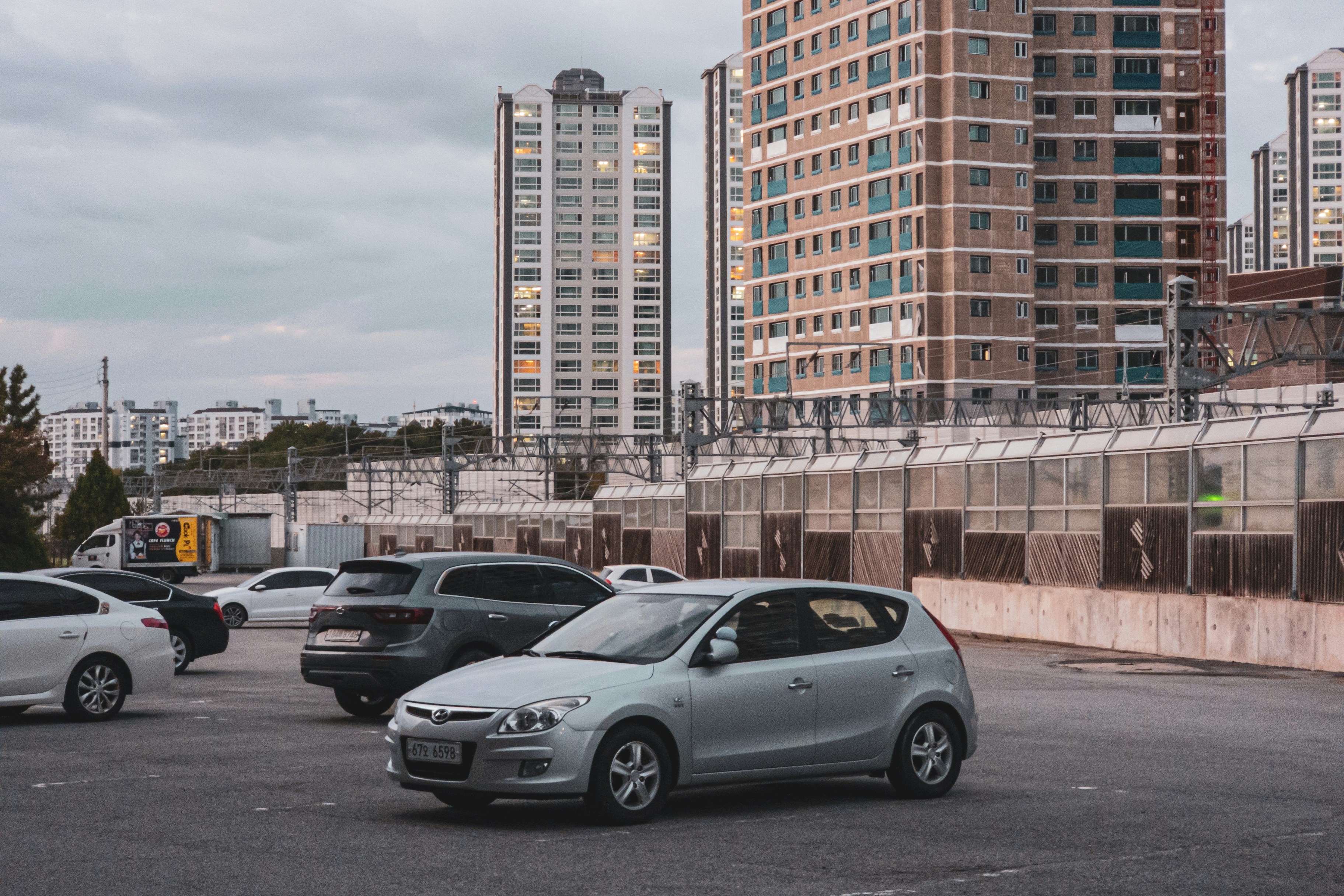 Row of pre-owned electric vehicles parked at an urban dealership lot