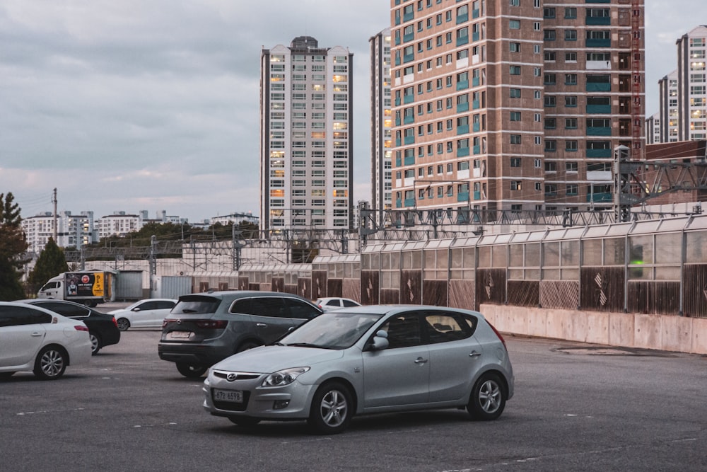cars parked on the side of a road with buildings in the background