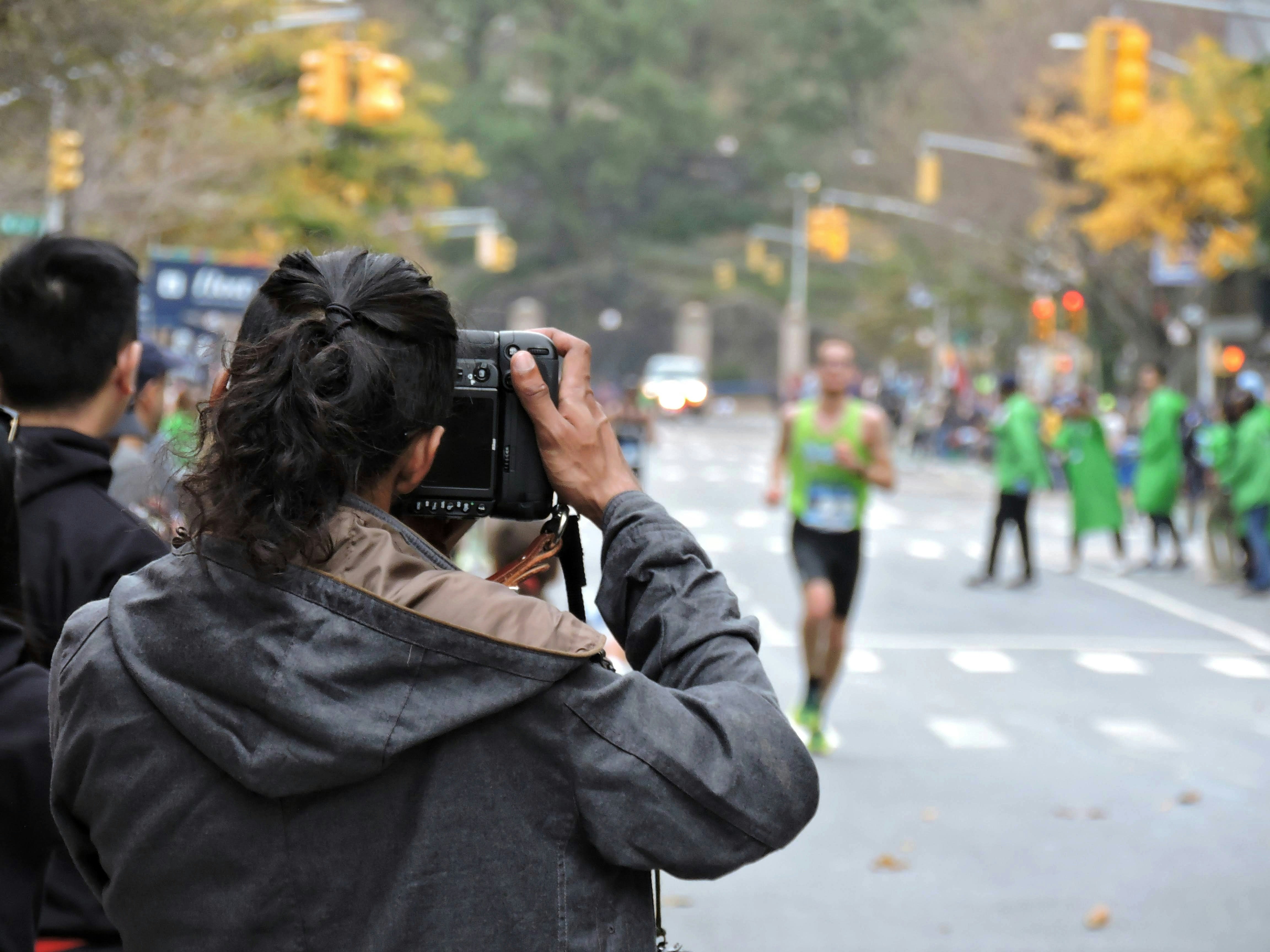 Runners in motion on a city street, legs and shoes visible, motion blur capturing speed and energy, documentary athletic photography