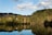 a body of water with trees and hills around it