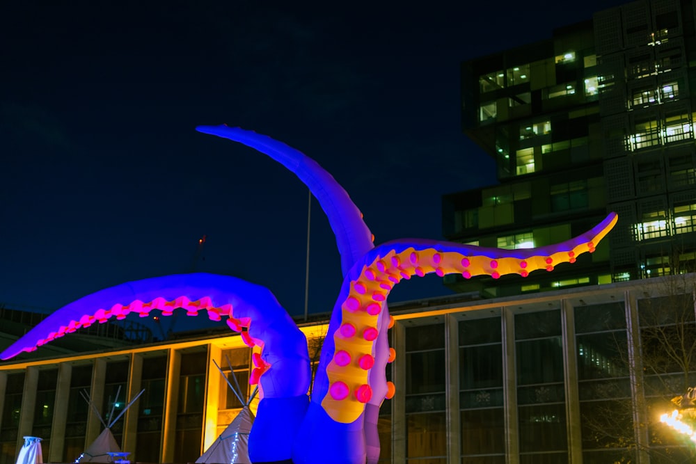 Una grande scultura colorata di fronte a un edificio