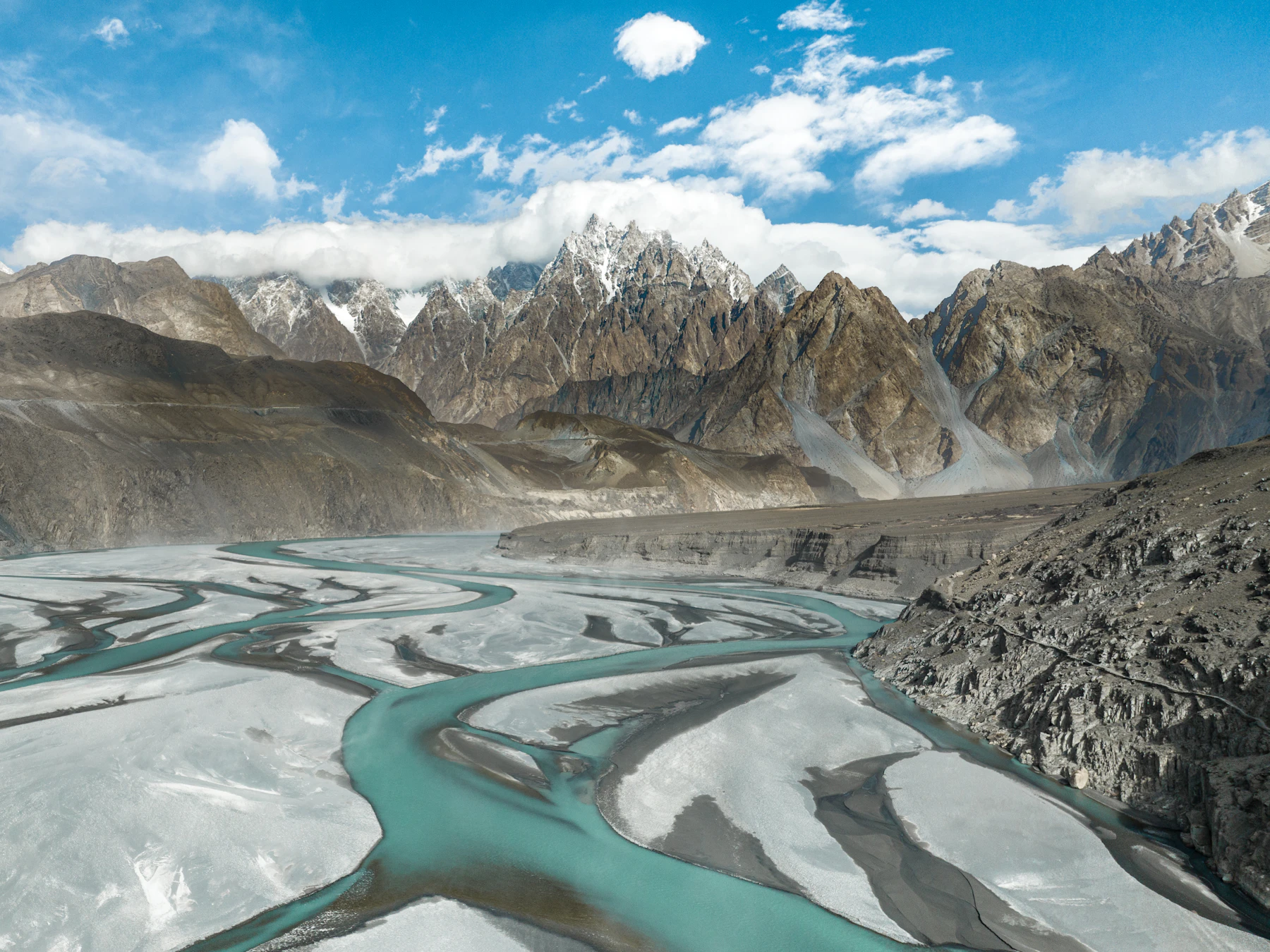 Braided turquoise river beneath mountain ridges in Hunza