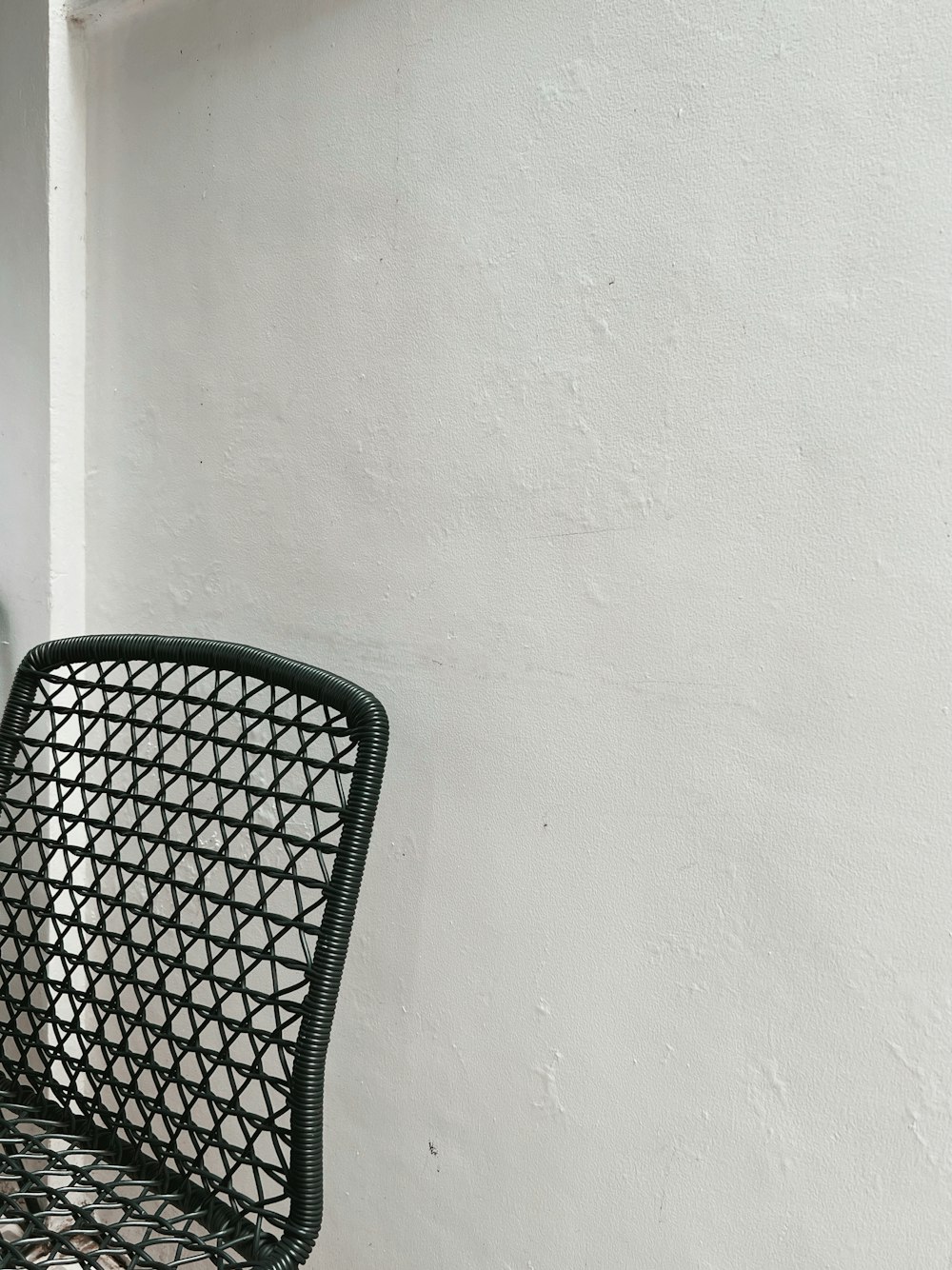 a black and white photo of a chair against a white wall