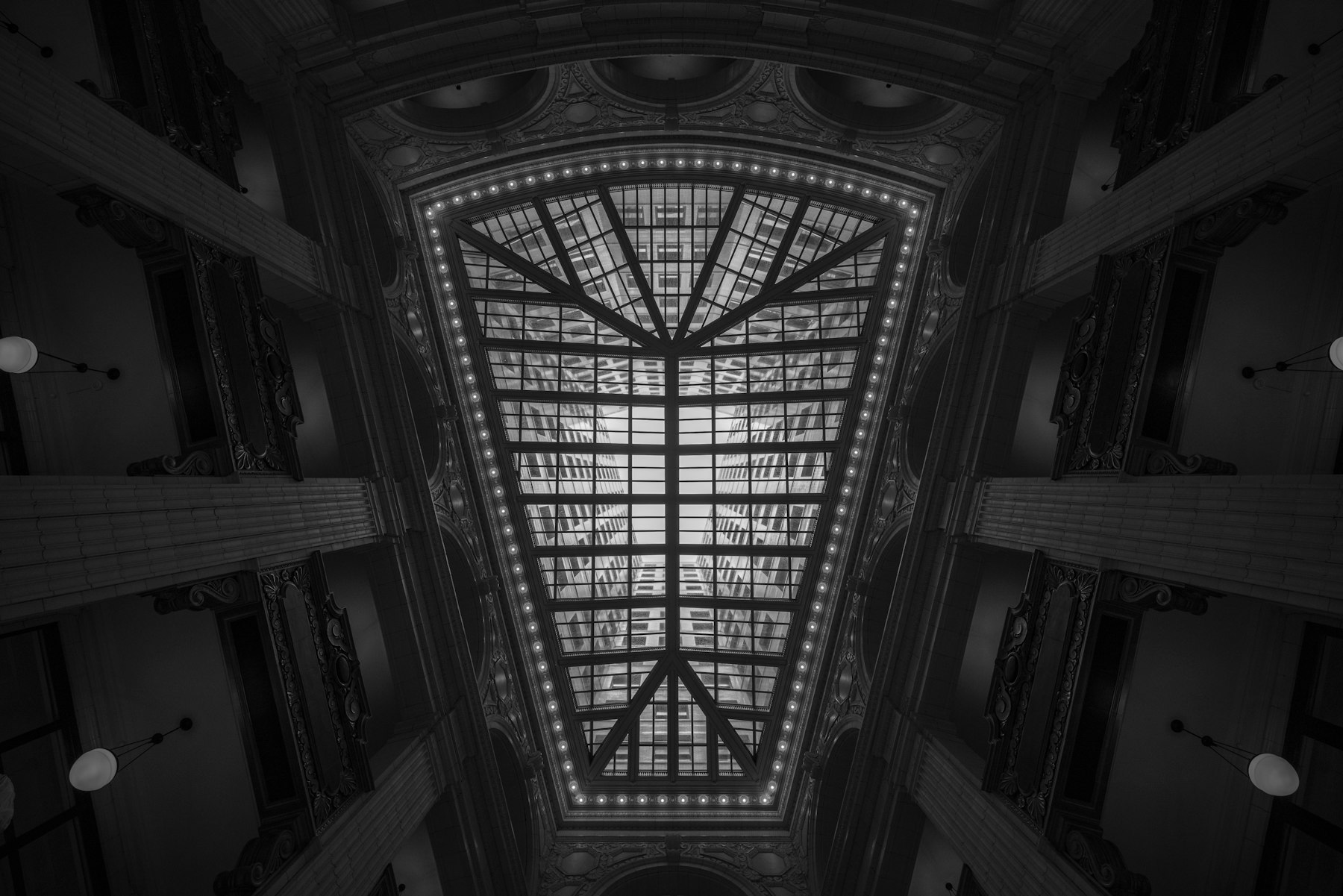 Light through a geometric glass skylight in an ornate Detroit interior, photographed in black and white.
