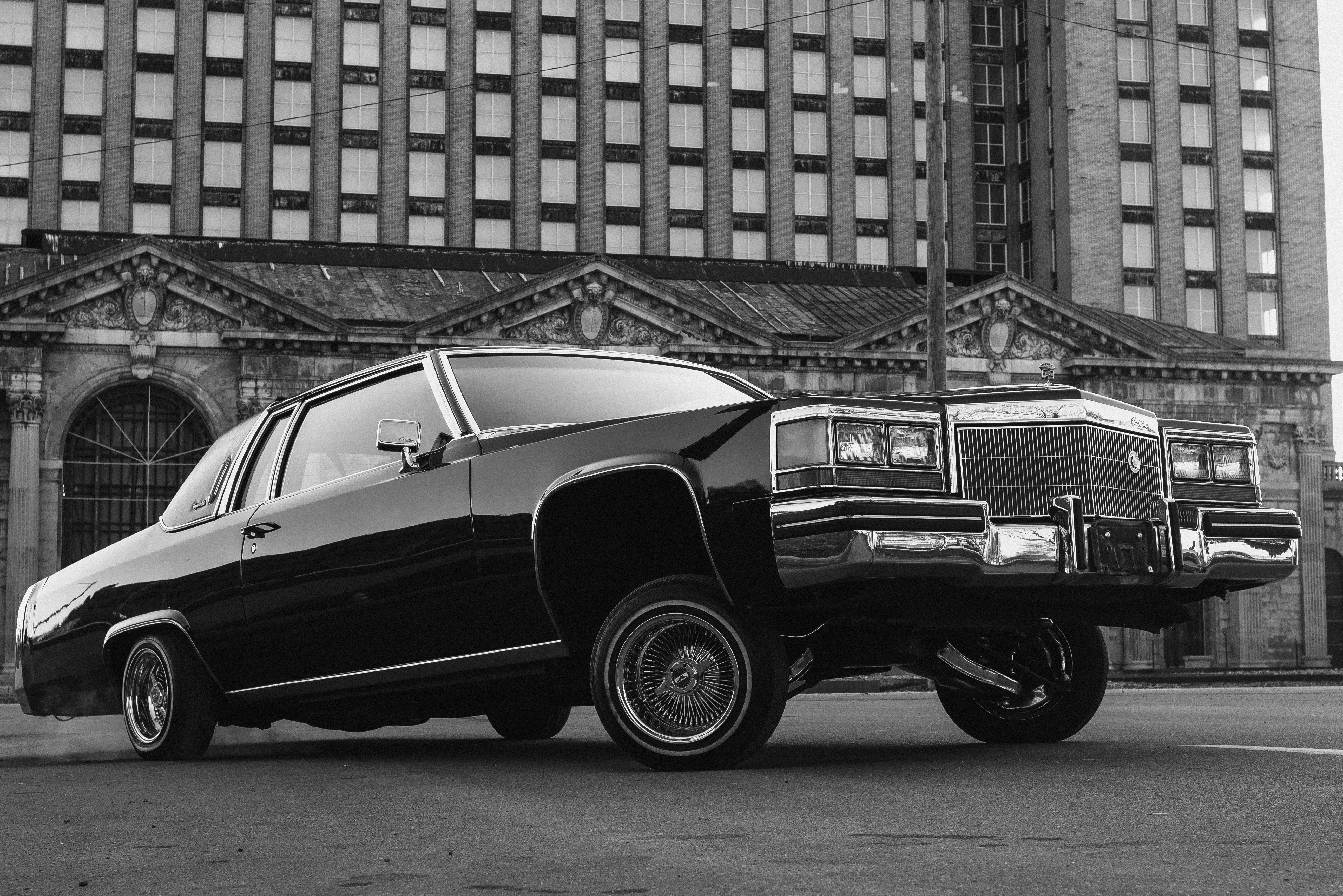 ein Schwarz-Weiß-Foto eines Autos, das vor einem Gebäude geparkt ist