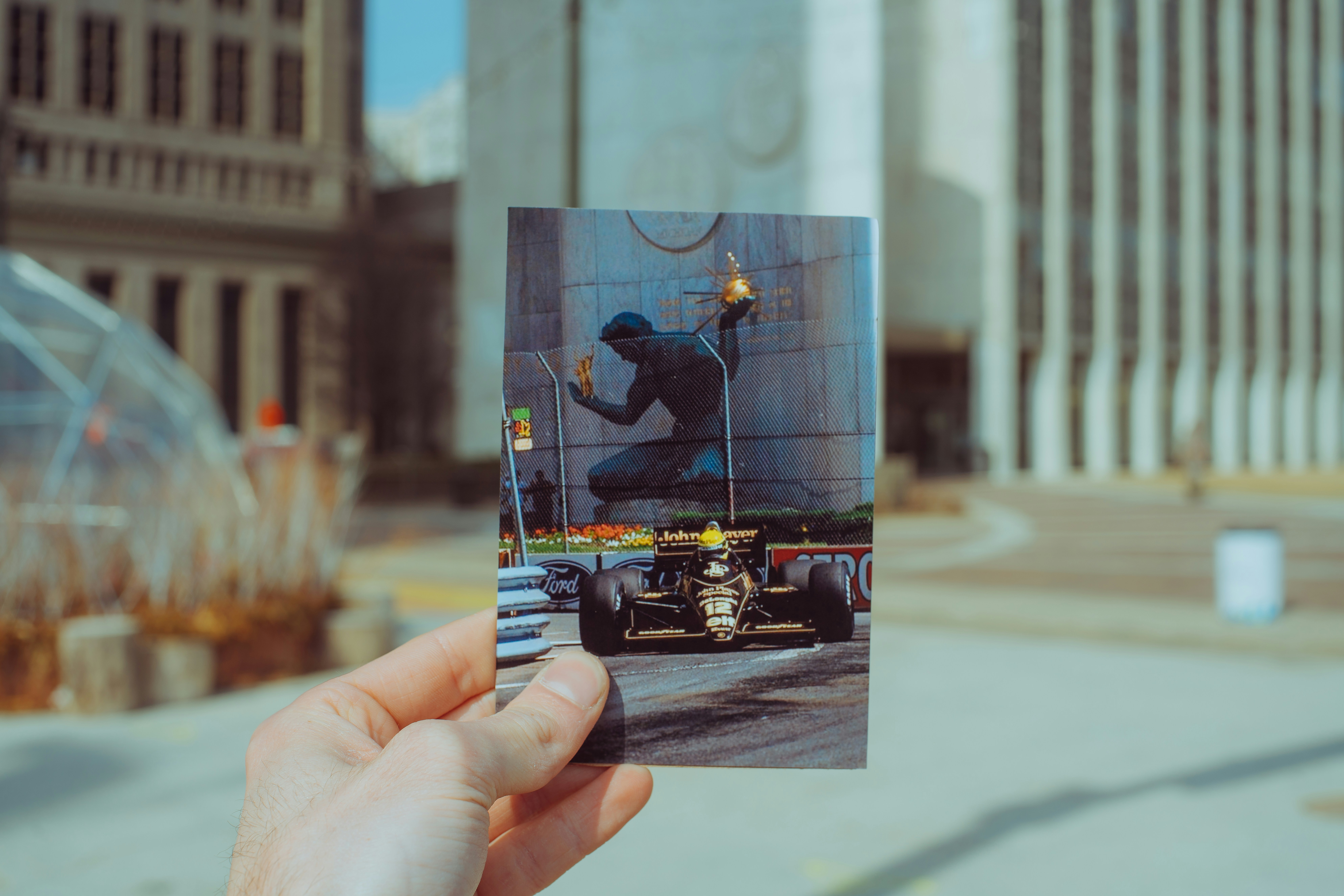 Eine Hand, die ein Bild einer Person in einem Auto hält