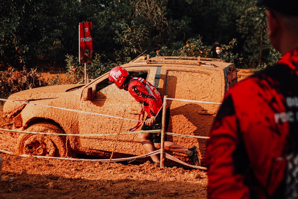 赤いジャンプスーツを着た人がトラックに土を吹きかける