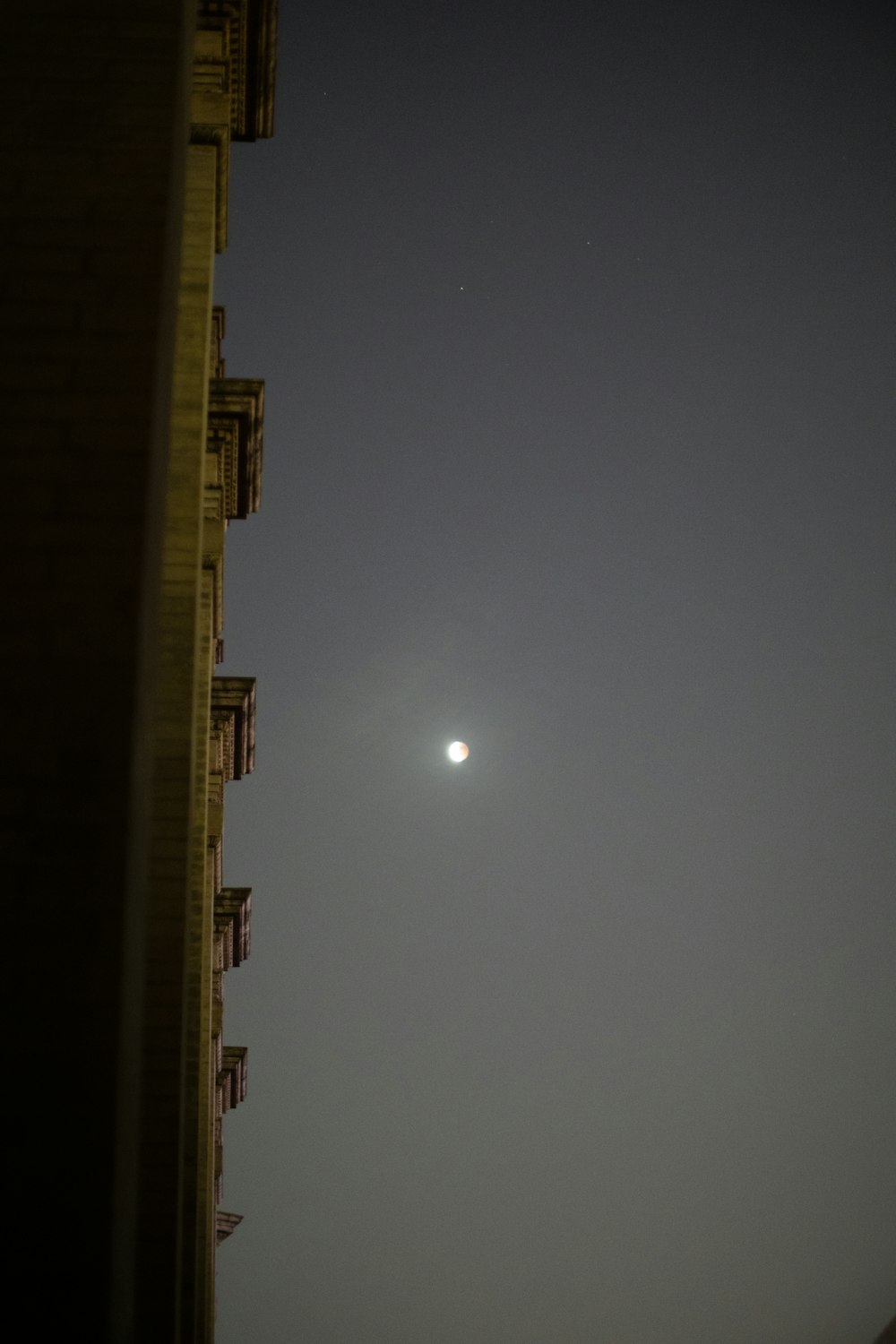 Un bâtiment avec une lune dans le ciel