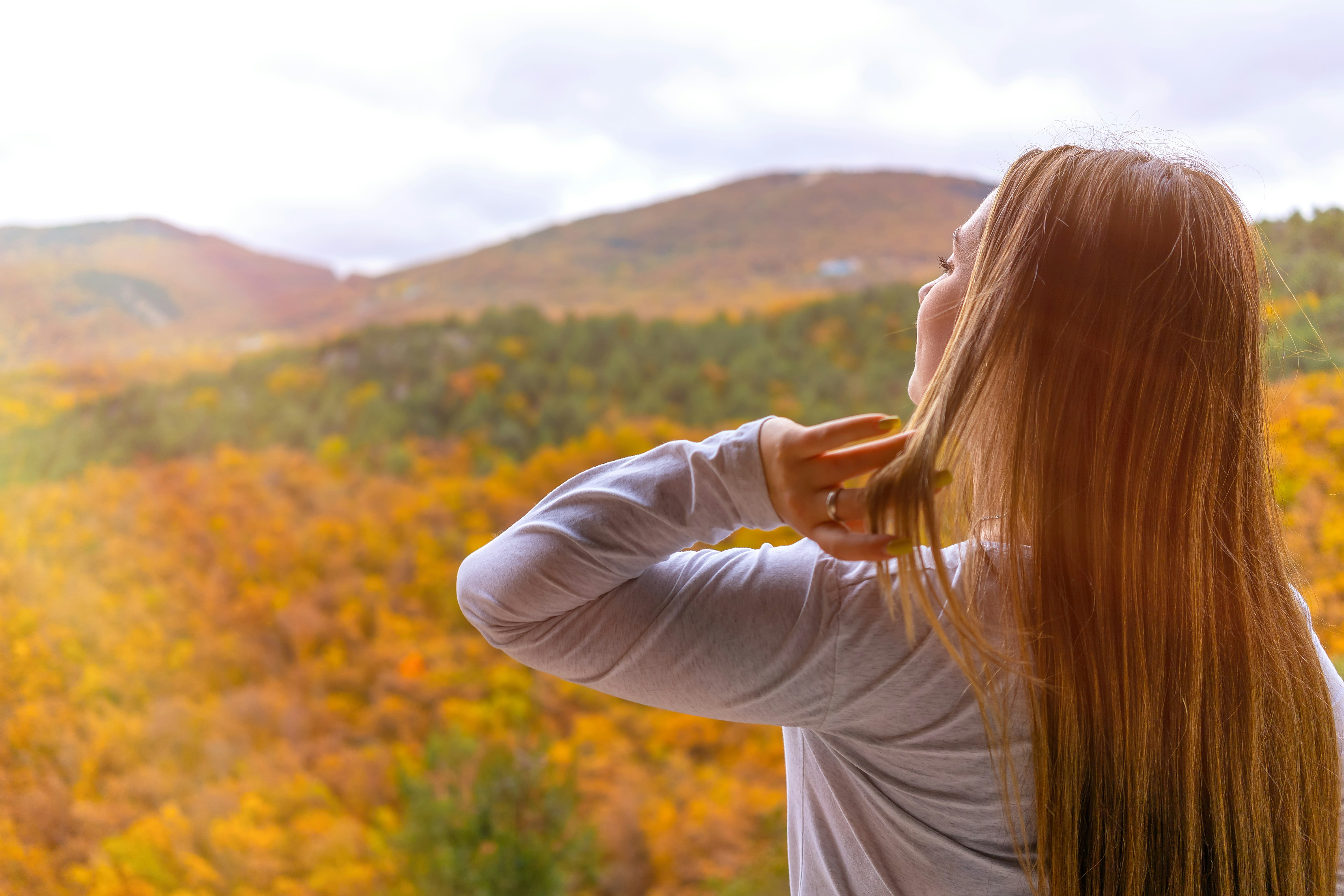 A young girl (brunette) touches her long hair with her hand against the backdrop of nature. Balaklava, Sevastopol, Baidarskaya valley, Murzak-koba. November 2022