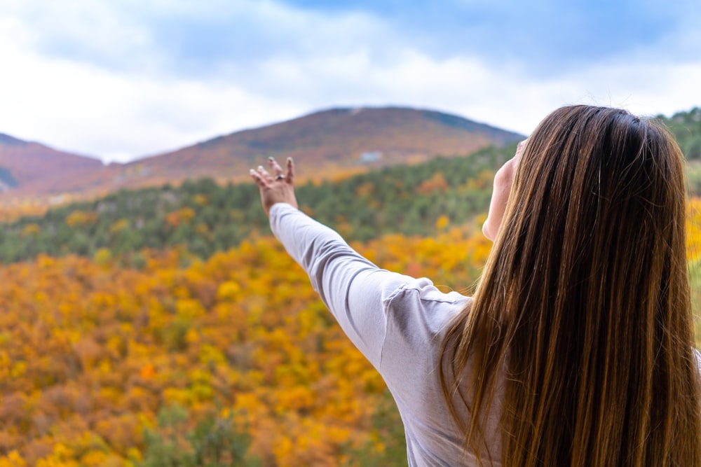 a person with the hands up in a field of flowers