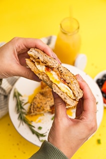 a person holding a sandwich