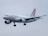 A commercial airplane bearing the Croatia Airlines branding is captured in mid-flight against a cloudy gray sky. The aircraft has a sleek white body with distinctive red and blue checkered patterns on the vertical stabilizer.