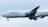 An aircraft featuring the Lufthansa airline logo is in flight, with its landing gear extended. The plane's body is mostly white, and it is flying against a backdrop of an overcast sky.