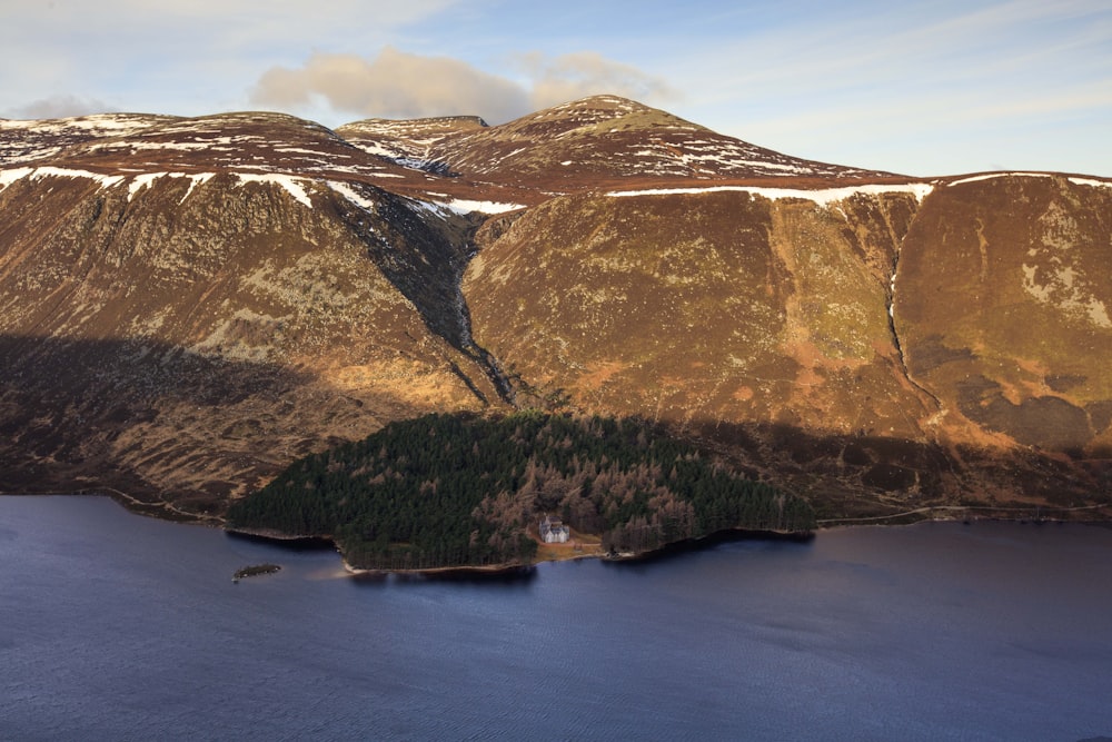 Une petite île dans l’eau avec des montagnes en arrière-plan