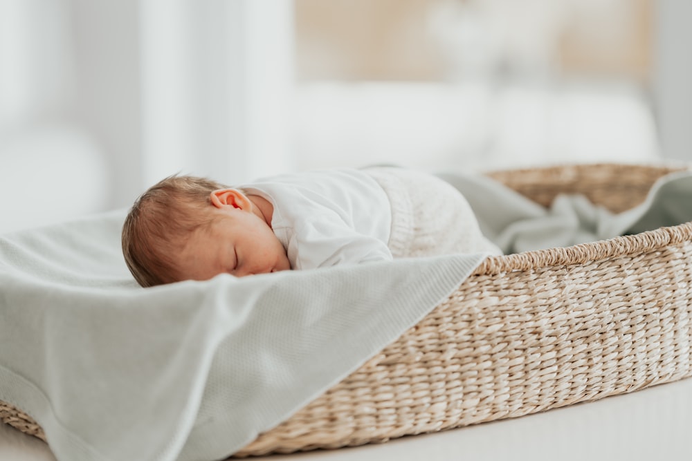 a baby sleeping in a basket