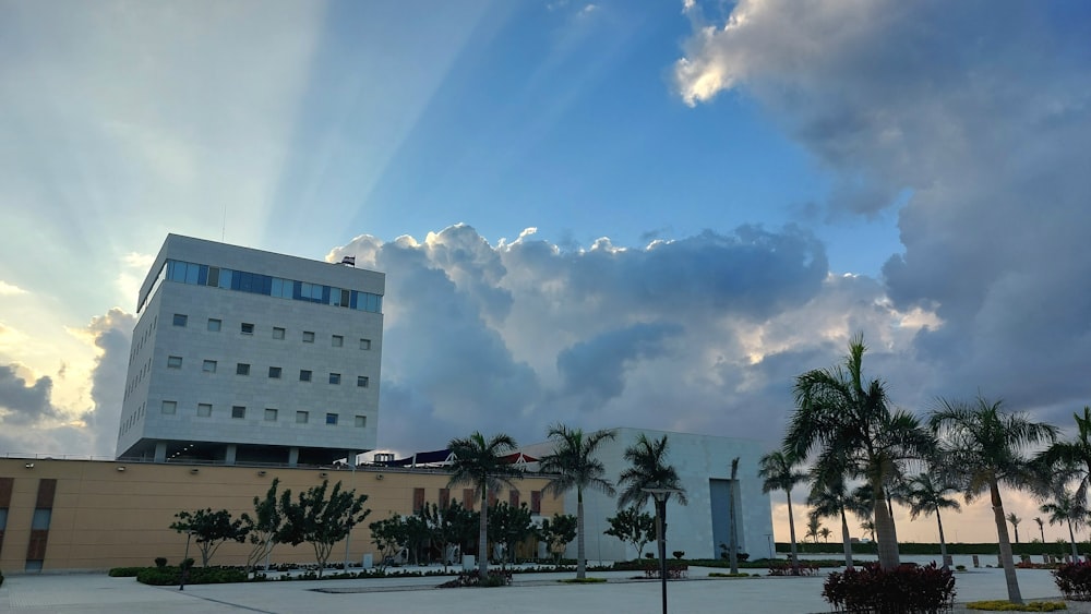 a building with palm trees and a beach in the background