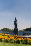 a statue of a person surrounded by flowers