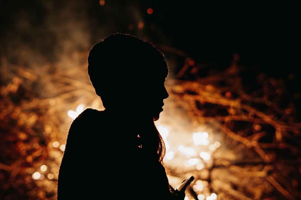 una persona in piedi davanti a un fuoco