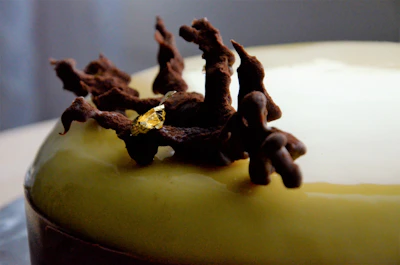 Close-up of a beautifully decorated luxury cake with glowing gold accents on a sleek black plate.