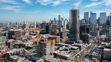 A dynamic cityscape showing construction cranes and growing buildings symbolizing project expansion.