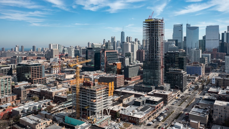 Engineer reviewing construction site plans with city skyline in background.
