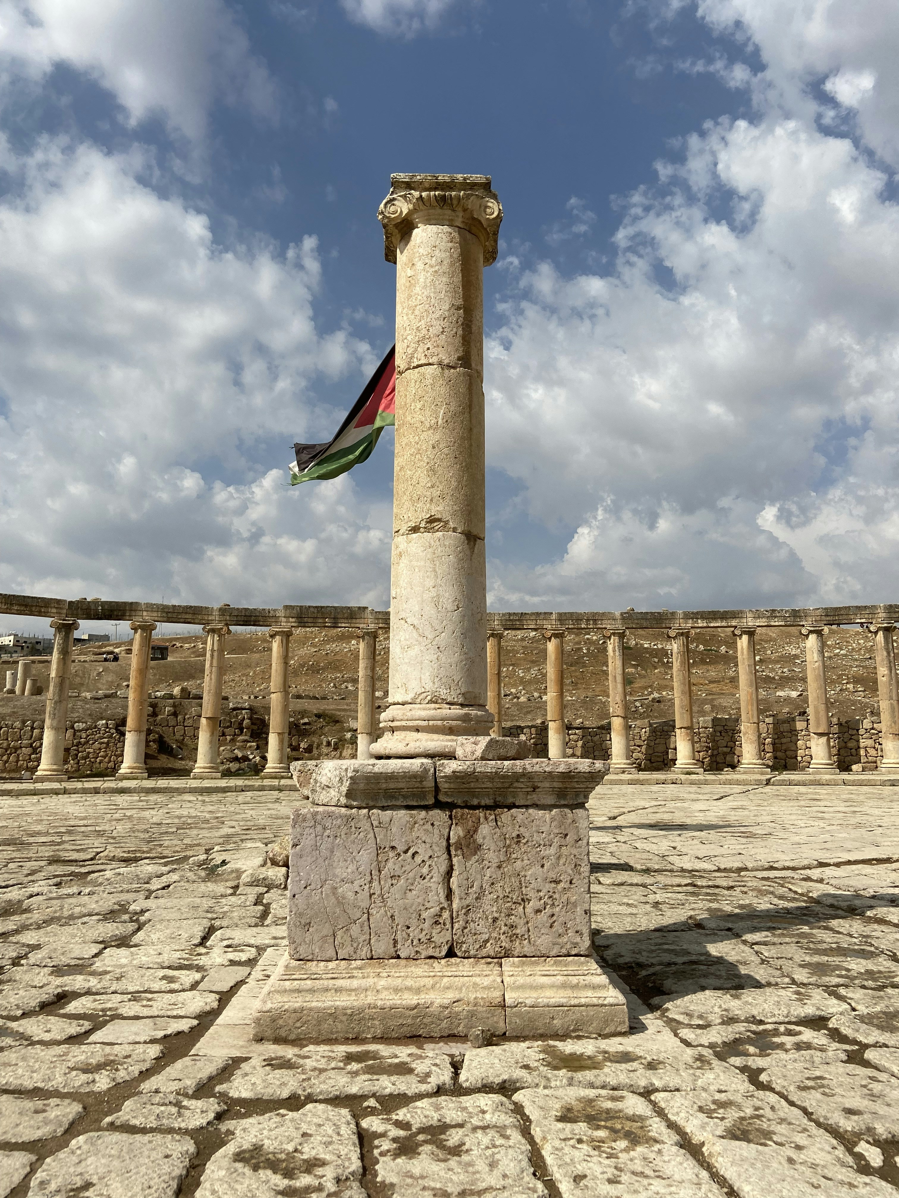 a stone pillar with a flag on top