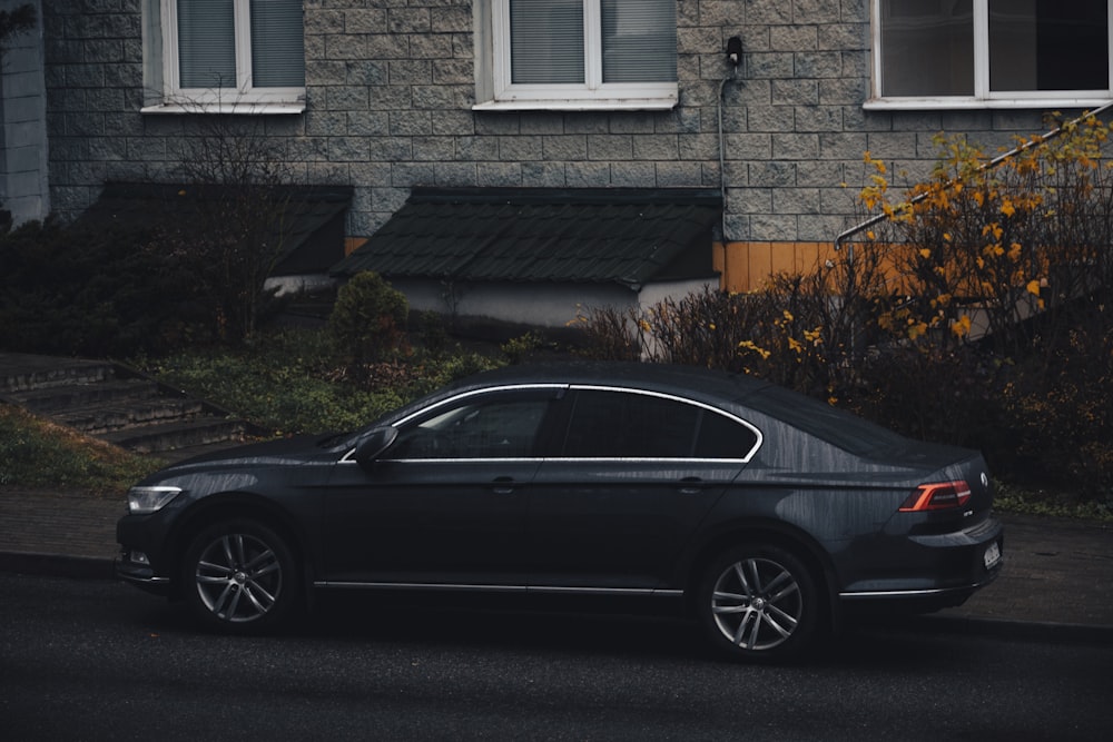 a black car parked in front of a house