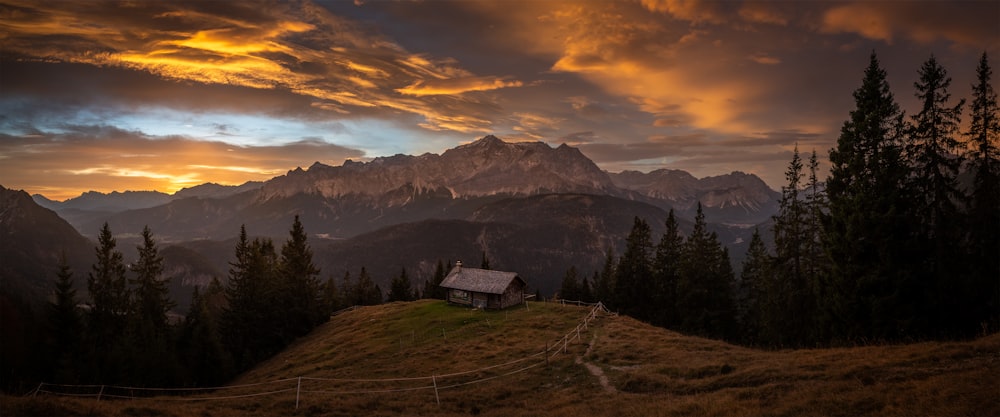 a house in a valley with mountains in the background