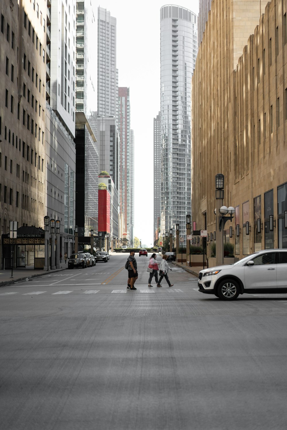 people walking on a street between tall buildings