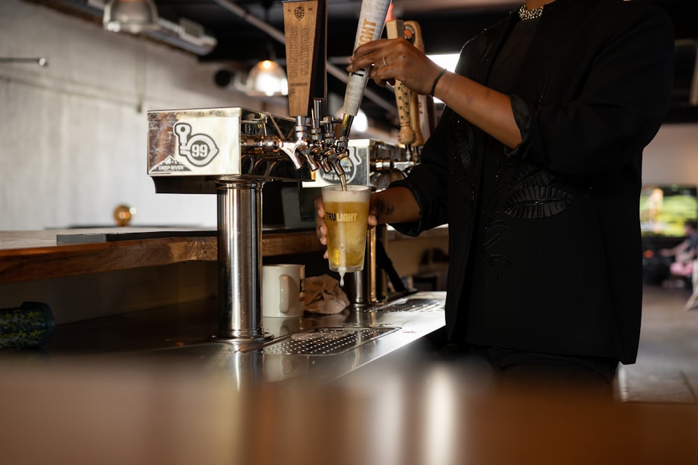 a person pouring a drink into a glass