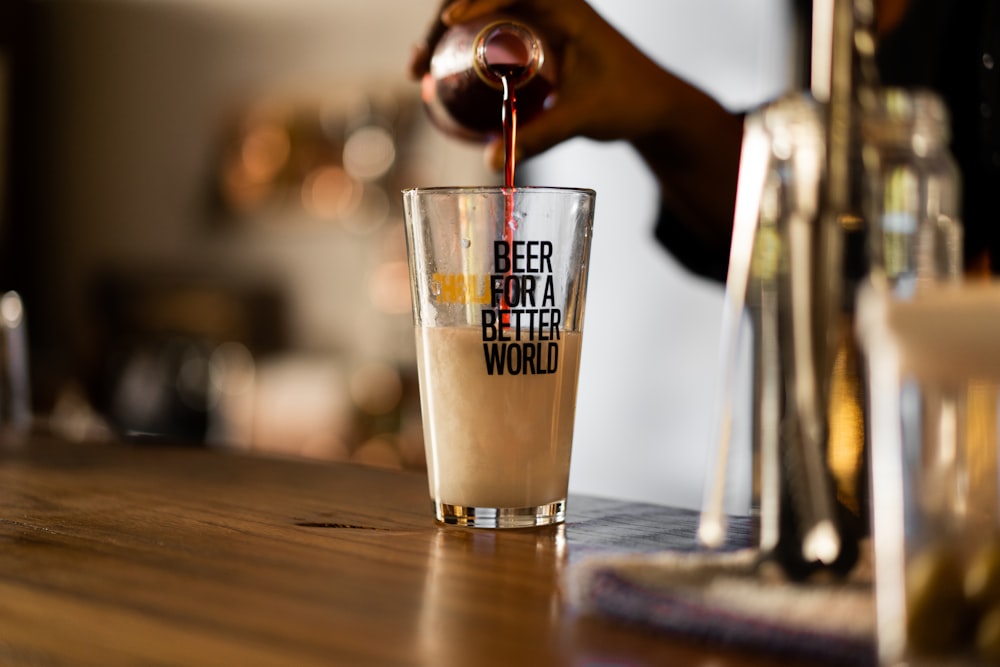 a hand pouring a drink into a glass