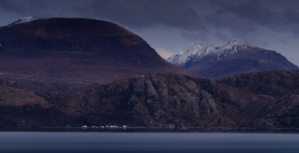 a body of water with mountains in the back