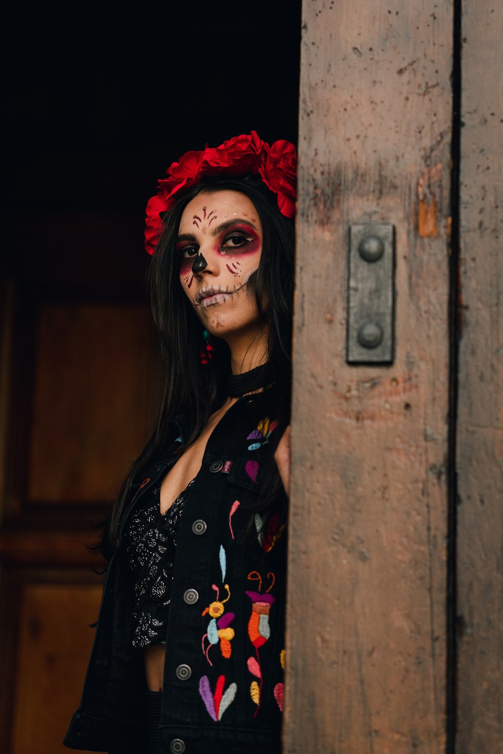 uma mulher com cabelos ruivos e um vestido preto com uma flor vermelha na cabeça