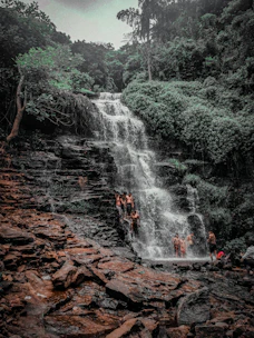 Small group enjoying a scenic waterfall tour in Lombok surrounded by greenery.