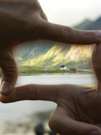 Close-up of hands holding a set of house keys with desert mountains in the background.