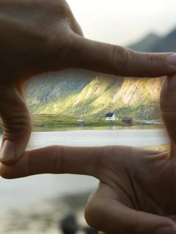 Close-up of hands holding a set of house keys with desert mountains in the background.
